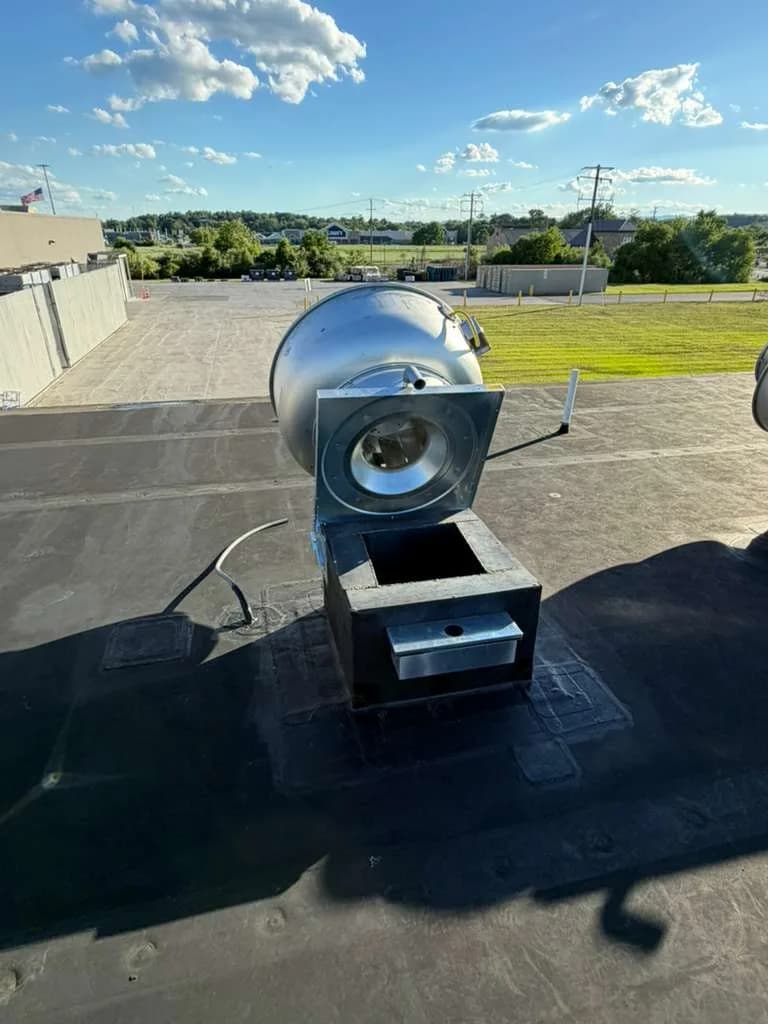Rooftop commercial exhaust fan opened for maintenance and repair